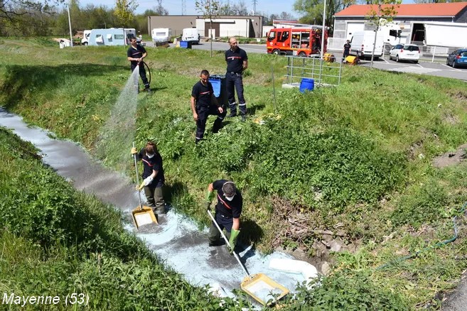 Elimination de poudre d'extincteur dans un ruisseau.
